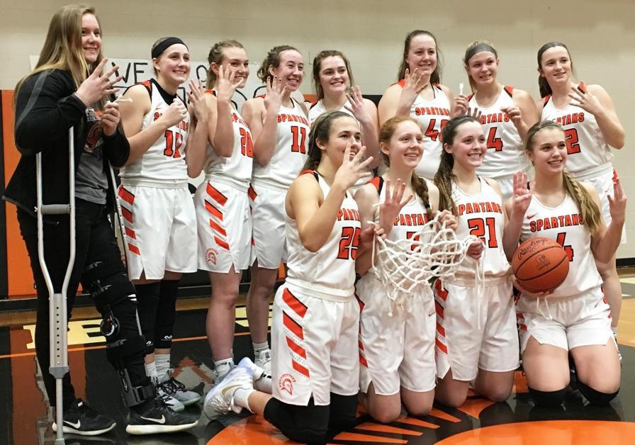 girls basketball team holding a net